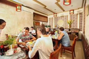 a group of people sitting at a table in a restaurant at Aquarius Grand Hotel in Hanoi