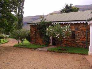 a stone house with a tree in front of it at Nooitgedacht Trout Lodge in Lydenburg
