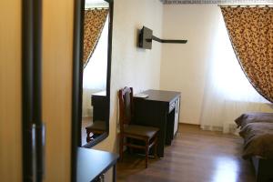 a room with a desk and a mirror and a bedroom at Astarta Inn in Kamianets-Podilskyi