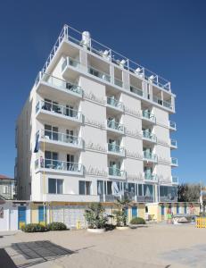 a tall white building with balconies on it at Residence Terminus in Rimini