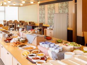 ein Buffet mit vielen Gerichten und Schüsseln. in der Unterkunft Hotel Pearl City Akita Kanto-Odori in Akita