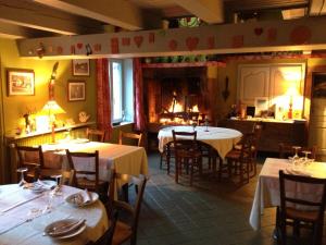 a restaurant with tables and chairs and a fireplace at Auberge de la Cholotte in Les Rouges-Eaux