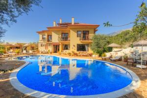 a large swimming pool in front of a house at Mandarin & Mango Boutique Hotel in Faralya