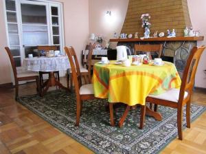 a dining room with a table and chairs and a fireplace at Hostal Andalue Temuco in Temuco