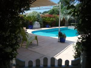 a swimming pool with a chair and an umbrella at Mer Golf Esterel in Saint-Raphaël