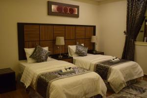 a hotel room with two beds in a room at Al Shiraz Suites in Muhayil