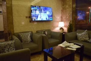 a living room with couches and a flat screen tv at Al Shiraz Suites in Muhayil