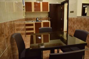 a kitchen with a glass table and chairs at Al Shiraz Suites in Muhayil +27 photos