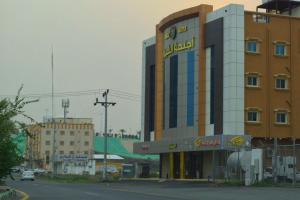a building with a sign on the side of a street at Al Shiraz Suites in Muhayil