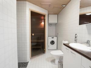 a bathroom with a sink and a washing machine at Kotimaailma Apartments Kuopio in Kuopio +130 photos