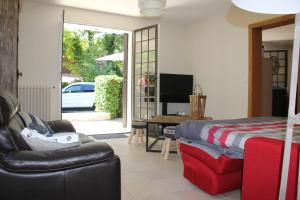 a bedroom with a bed and a couch and a television at Le Charme des Dunes in Arcachon