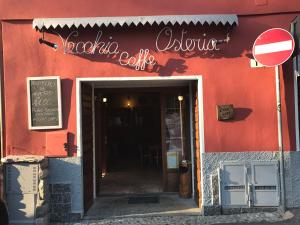 un edificio rosso con un cartello per un ristorante di Locanda Vecchia Osteria a Varese