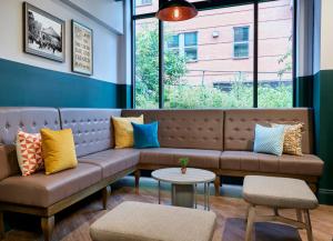 a couch in a room with colorful pillows on it at Leonardo Hotel Manchester Central - Formerly Jurys Inn in Manchester