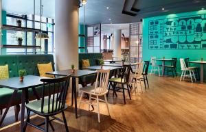 a group of tables and chairs in a restaurant at Leonardo Hotel Manchester Central in Manchester