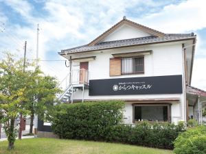 uma casa branca com um sinal na frente. em Riverside Hotel Karatsu Castle em Karatsu