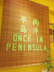 una señal que dice una vez en penghai en una pared en Once In Peninsula Guesthouse by Nestcove en Melaka