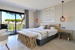 a bedroom with a bed and a large window at Le Spinaker in Le Grau-du-Roi