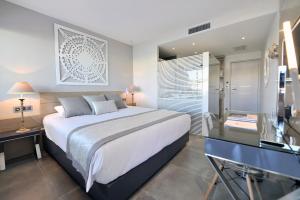 a bedroom with a bed and a desk and a window at Le Spinaker in Le Grau-du-Roi
