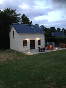 uma pequena casa branca com um telhado azul em La grange de la vallée em Hamars