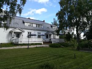 Hotelli Huiskankorpi Boutique Hotel في Nivala: منزل أبيض كبير مع حديقة أمامه