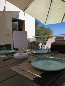 uma mesa com pratos e talheres por cima em appartement Calvi em Calvi