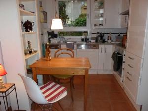 una pequeña cocina con mesa de madera y sillas en Ferienwohnung Bella Rosa, en Freiburg im Breisgau