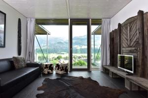 salon z kanapą i dużym oknem w obiekcie Glas House - Design Holiday Home w mieście Piesendorf