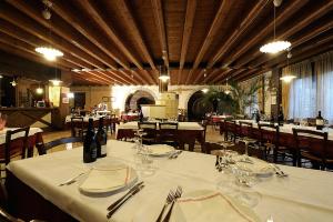 a dining room with tables and chairs with white table cloth at Agriturismo Roeno in Belluno Veronese
