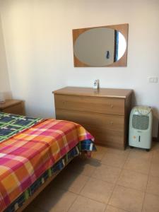 1 dormitorio con cama, tocador y espejo en Apartment in Residence King's Bay en Fano