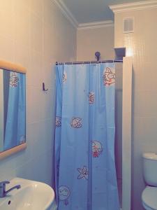 La salle de bains est pourvue d'un rideau de douche avec des poissons. dans l'établissement Vesna Apartments in the Center, à Astana