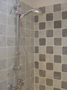 La salle de bains est pourvue d'une douche et d'une porte en verre. dans l'établissement B&B Brigitte & Alain, à Bruxelles