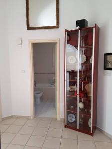 a bathroom with a toilet and a glass cabinet at Giorgio Vacation House in Pissouri