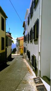 een lege straat met gebouwen en de oceaan op de achtergrond bij Apartments Madeira Old Town in Funchal