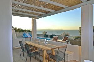 a patio with a table and chairs and a view of the ocean at Mastiha Villas in Chios