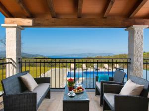 a patio with chairs and a table and a pool at Detached villa with private pool located on hill overlooking Kvarner in Hrvatini