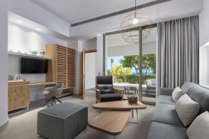 ein Wohnzimmer mit einem Sofa und einem Tisch in der Unterkunft Olympic Palace Hotel in Ixia