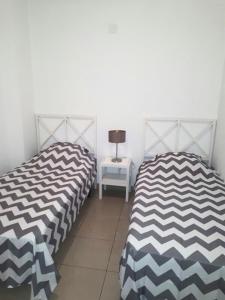 duas camas sentadas uma ao lado da outra num quarto em El Bosque em Playa Flamenca