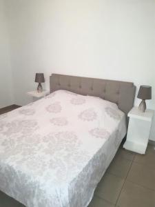 プラヤ・フラメンカにあるEl Bosqueのベッドルーム1室(白いベッド1台、ナイトスタンド2台付)