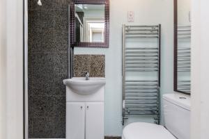 a bathroom with a sink and a mirror at Watford General Suites in Watford +53 photos