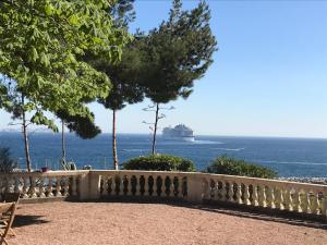 a cruise ship in the ocean behind a fence at Maison d'Hôtes La Bastide Bleue in Marseille