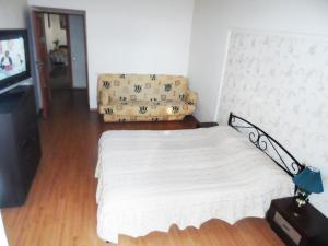 een slaapkamer met een wit bed en een televisie bij Apartment on Skorykovskyi Lane 4 in Dnipro