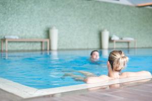 Eine Frau, die im Schwimmbad schwimmt. in der Unterkunft Hotel Lambrechtshof in Appiano sulla Strada del Vino