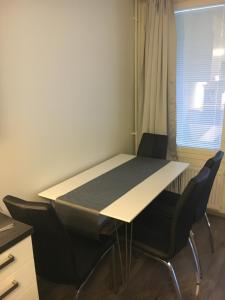 - une table et des chaises dans une chambre avec fenêtre dans l'établissement Bästlandia Apartments with Sauna, à Vaasa