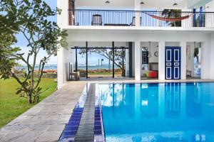 a villa with a swimming pool in front of a house at Culture Resort in Matara