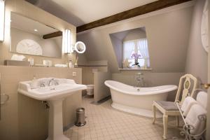 a bathroom with two sinks and a tub and a mirror at Romantik Hotel Zur Glocke in Trier