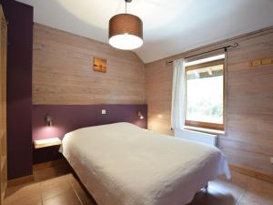 Duplex Chalet in Rendeux Ardennes with Sauna and Terrace في Verpré: غرفة نوم بسرير ابيض ونافذة