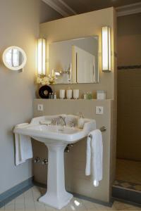 a white sink sitting under a mirror in a bathroom at Romantik Hotel Zur Glocke in Trier