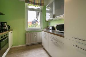 una cucina con pareti verdi e una finestra di Ferienwohnungen Proll a Bansin