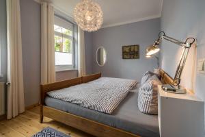 ein Schlafzimmer mit einem Bett mit einer Lampe und einem Fenster in der Unterkunft Ferienwohnungen Proll in Bansin