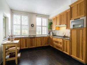 a large kitchen with wooden cabinets and a table at Luxury home in Gedinne with bubble bath and sauna in Gedinne